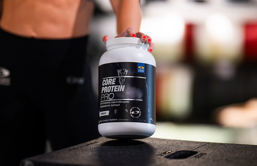 Bild p en person som hller i en burk Core Protein Pro.